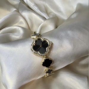 Black clover-shaped watch with gold-tone finish and adjustable bracelet.
