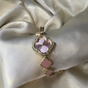 Pink clover-shaped watch with gold-tone finish and adjustable bracelet.